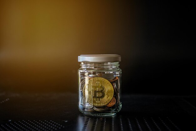 Gold bitcoin and money coin in glass jar on black background Crypto currency and finance concept