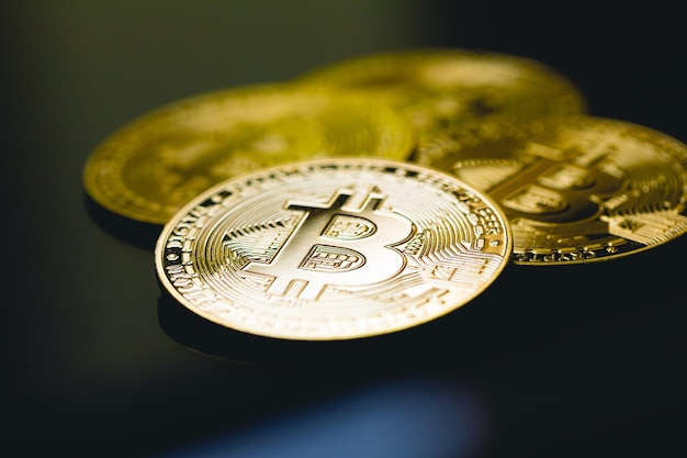 Gold coins of Bitcoin on the surface of table with glass