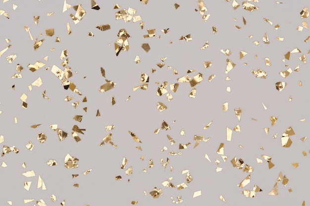 Gold confetti sparkles on grey Christmas background, golden chic holiday backdrop.