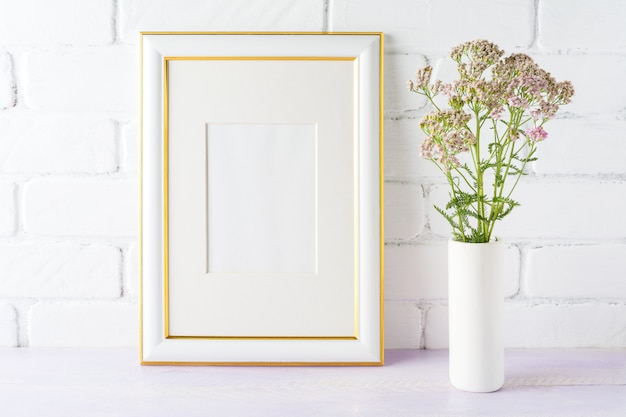 Gold decorated frame mockup with pink flowers in cylinder vase