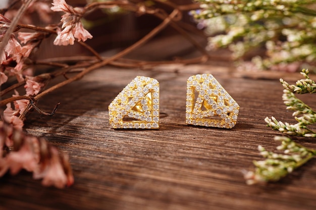 gold earrings on wood background