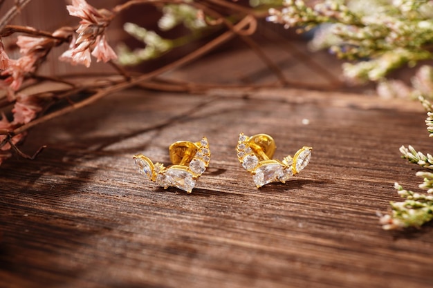 gold earrings on wood background