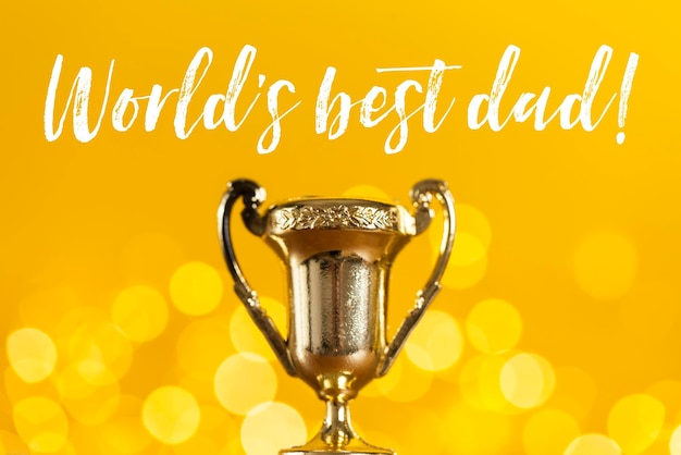 Gold father's day award trophy against bright yellow background