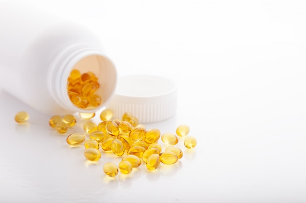 Gold fish oil scattered from pill bottle