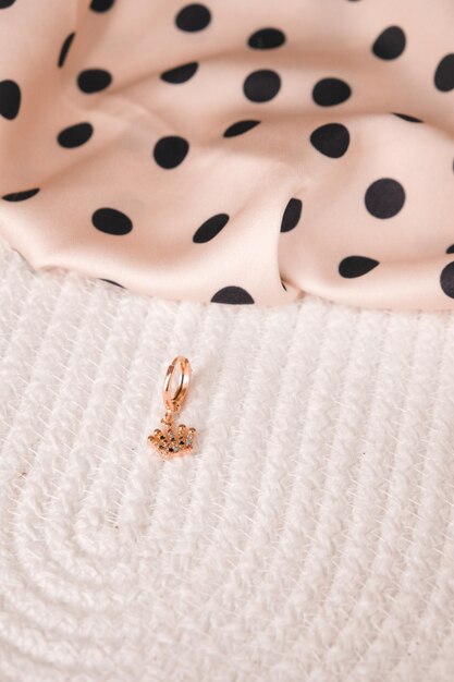 A gold flower charm is on a white background.