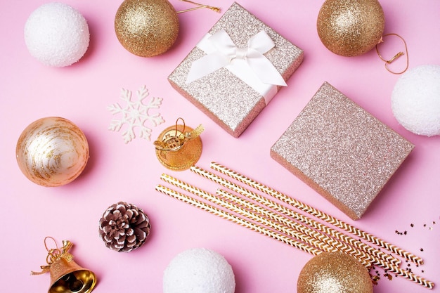 Gold gifts and Christmas decor on a pink background Flat lay style