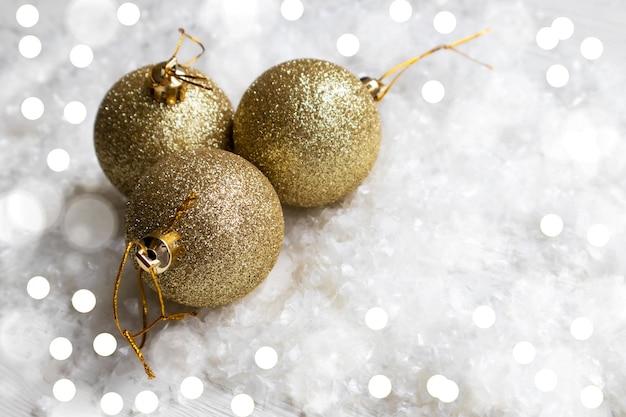 Gold glittering balls for New Years Christmas tree on a white background with space for text Layout of a postcard poster