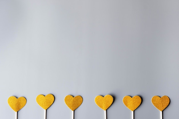 Gold hearts on gray paper wall. happy valentine's day, minimalism concept