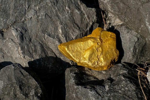 Photo gold nugget and grey granite stone background