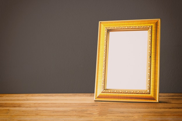 Gold photo frame on wooden