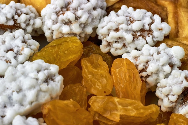 Gold raisins and peanuts dissolve in glaze Background from dried fruits