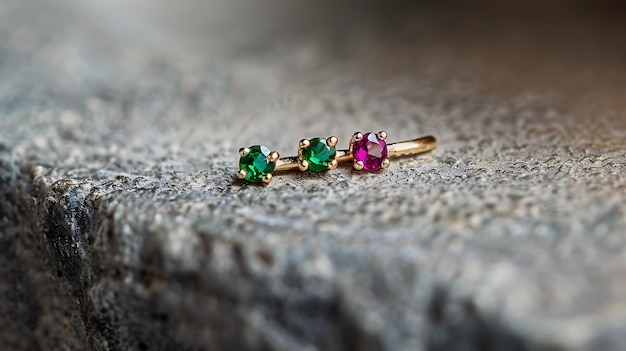 a gold ring with a pink gem sits on a grey stone surface