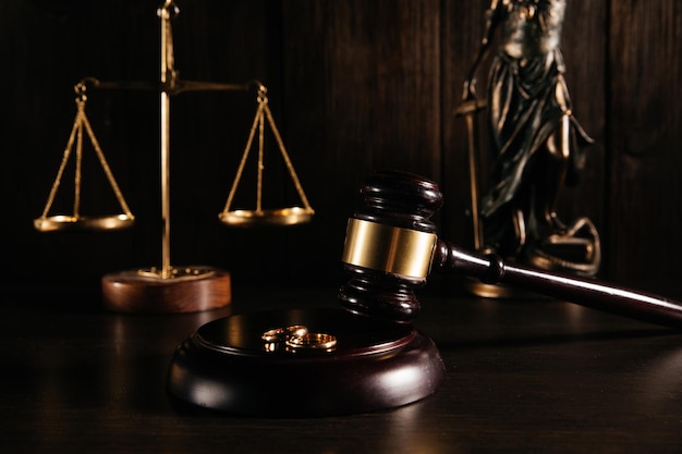 Gold rings on wooden mallet in a courtroom Divorce concept