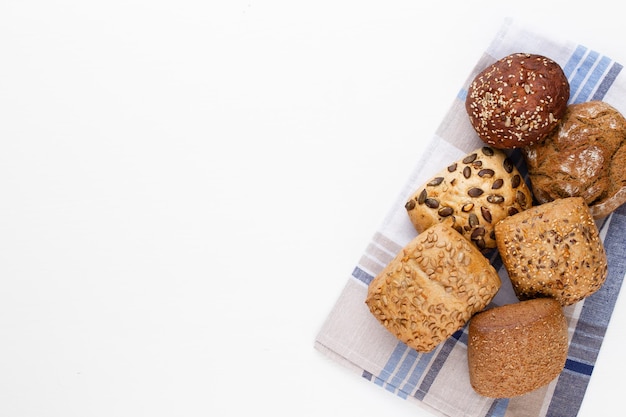 Gold rustic crusty loaves of bread and buns on wooden background Still life captured from above top view flat lay