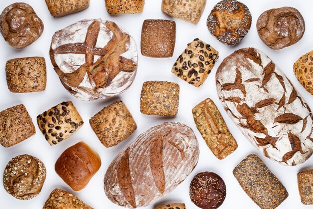 Gold rustic crusty loaves of bread and buns on wooden background