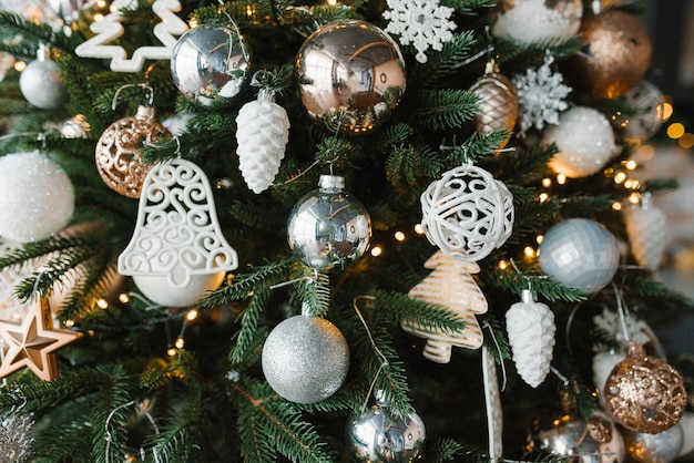 Gold silver and white Christmas toys on the Christmas tree closeup Festive background for copy space