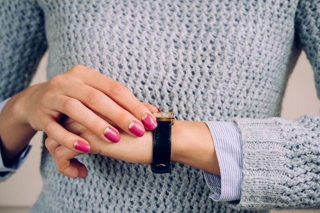 Gold watch with a leather strap on female hand