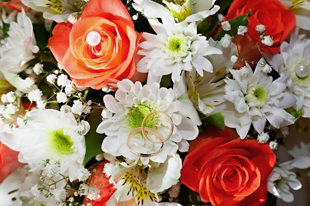 Gold wedding rings on a bouquet of flowers for the bride