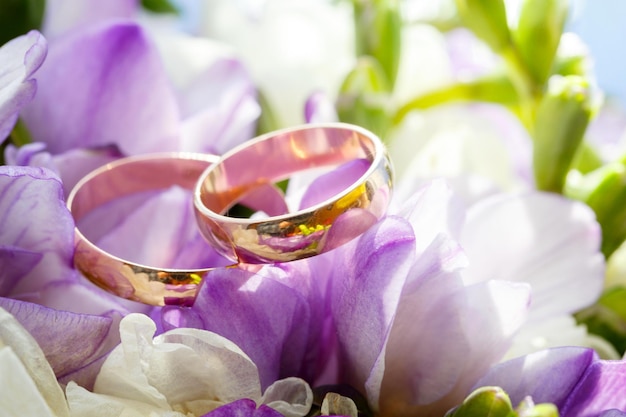 Gold wedding rings on a bouquet of flowers for the bride