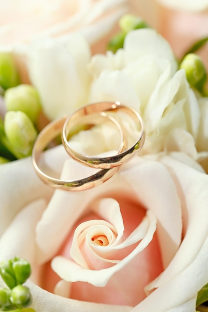 Gold wedding rings on a bouquet of flowers for the bride