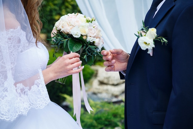 Gold wedding rings in the hands of the newlyweds