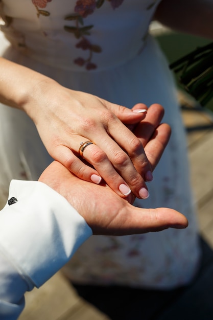 Gold wedding rings in the hands of the newlyweds