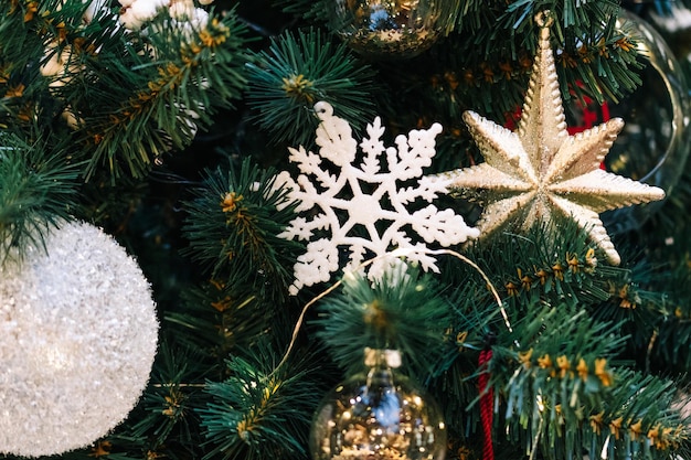 Gold and white christmas balls with sparkles on a christmas tree closeup