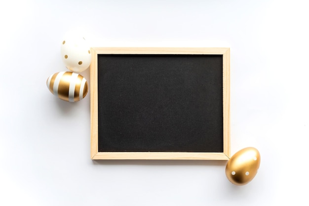 Gold white eggs on a white background with space for copy space for text in a frame Minimal concept View from above Easter card soft selective focus