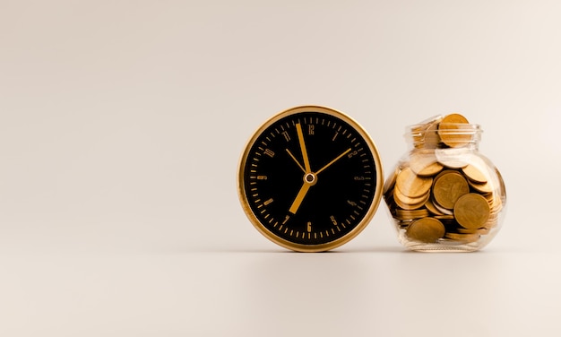 Golden alarm clock and coin in glass bottle money saving idea