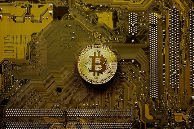 Golden bitcoin on computer motherboard, Bitcoin mining concept