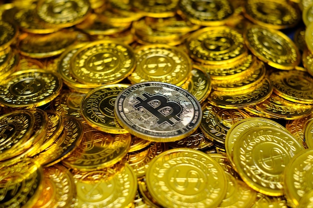 Golden bitcoin cryptocurrency on pile gold coins a lot of