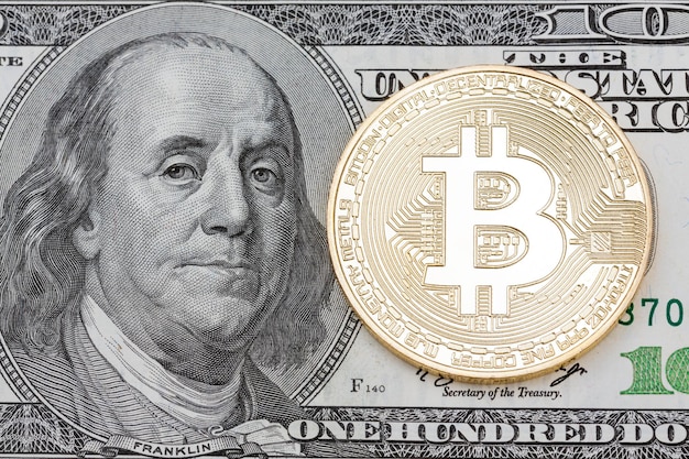 Golden bitcoin on hundred dollars banknote background