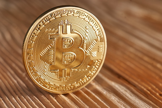 Golden bitcoin on wood