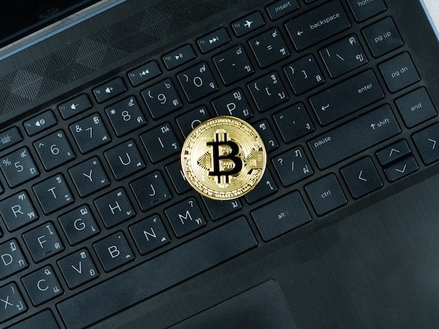 Golden bitcoins on keypad of laptop black color the digital money cryptocurrency concept