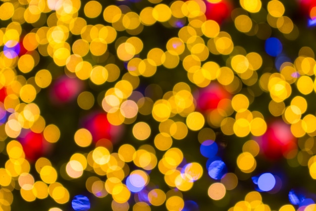 Golden Bokeh of Christmas balls and Christmas tree with light background