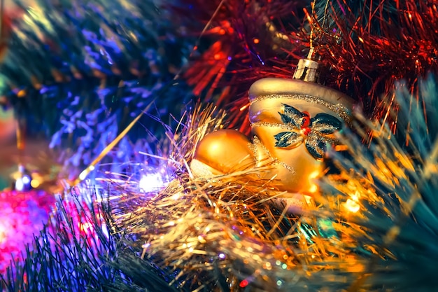 Golden boot toy on a christmas tree among the shiny garlands