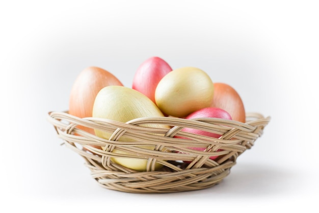 Golden bronze and pink Easter eggs in basket isolated on white background Design element for greeting cards poster or banner