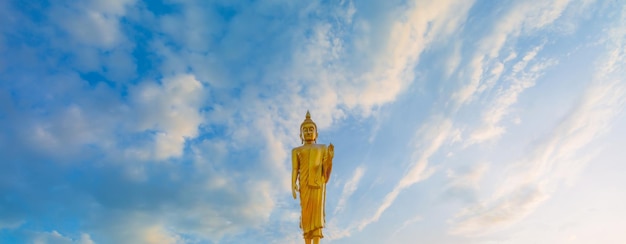 golden buddha and sky,Golden Buddha statue with blue sky background.