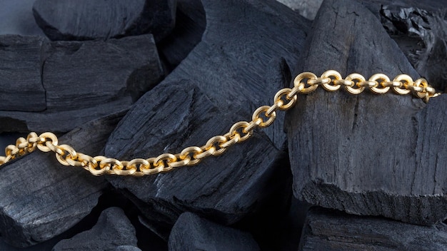 Golden chain on black coal background Close up photo