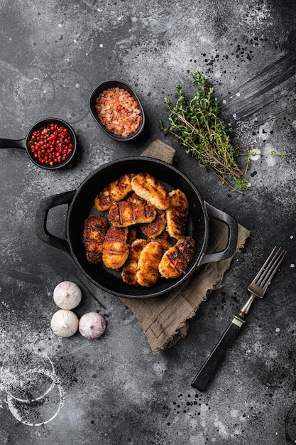 Golden chicken nuggets frying in hot oil set on black dark stone table background top view flat lay with copy space for text