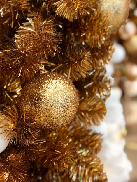 Golden Christmas ball on Christmas tree decoration holidays background