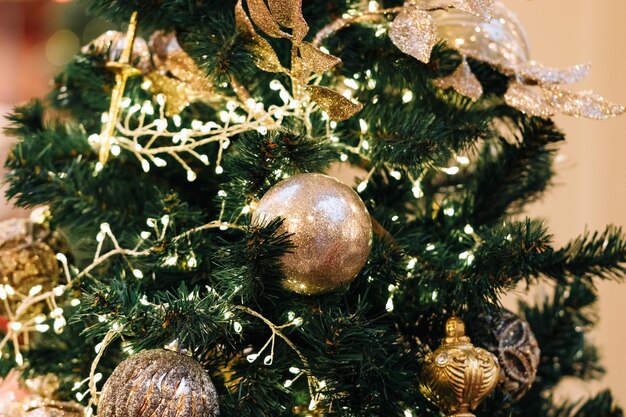 Golden Christmas balls garlands and decorations on the New Year tree closeup