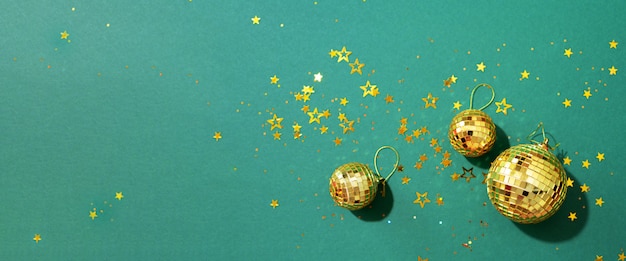 golden christmas balls with shiny stars on green background