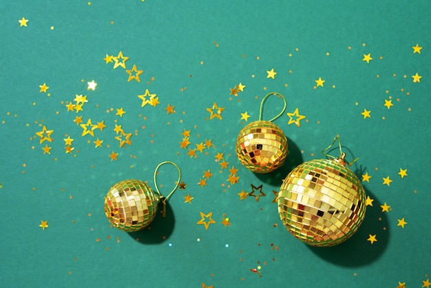 golden christmas balls with shiny stars on green background