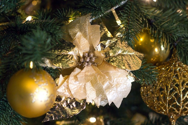 Golden Christmas tree decoration a flower on a Christmas tree with a garland near the mirror