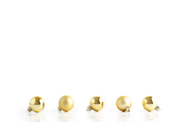 Golden Christmas tree toys on white background with reflection