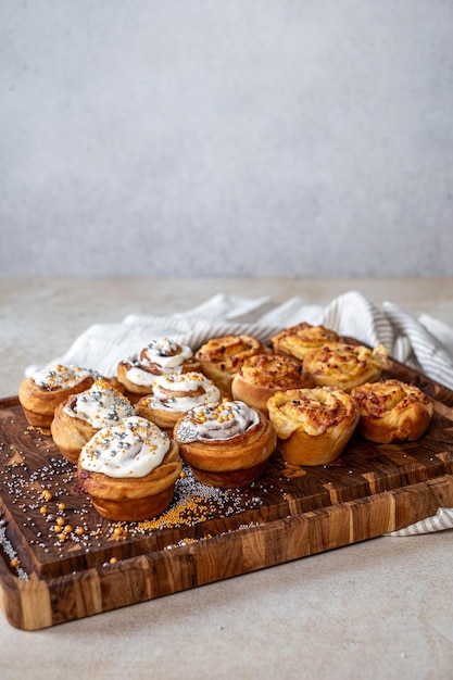 Photo golden cinnamon rolls with icing on a striped cloth and wood board ample copy space above for text or design elements on a white background