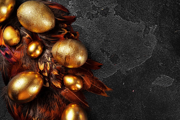 Golden Easter eggs on red bird feathers close up