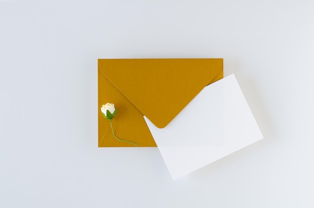 Golden envelope with card and roses on white background