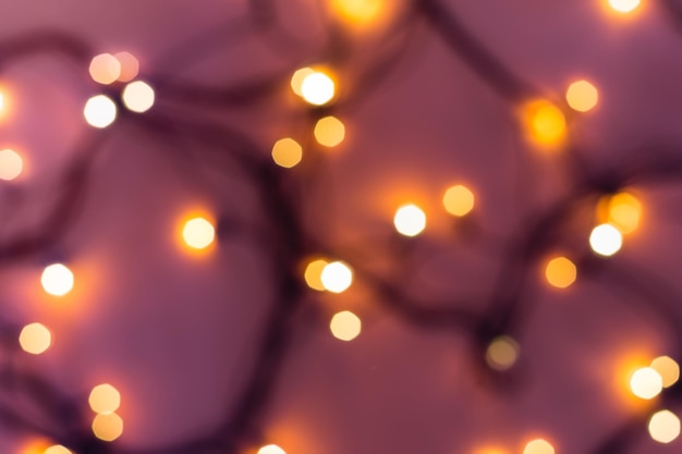 Golden festive bokeh lights on blurred pink background Christmas or party concept